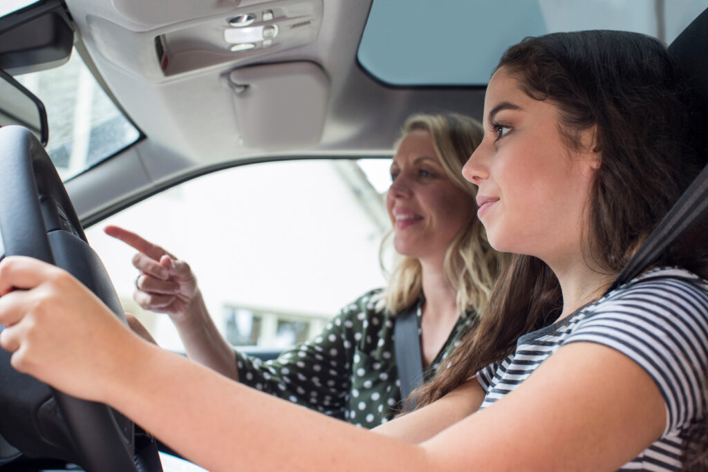 Learner driver receiving guidance from her instructor during a driving lesson.